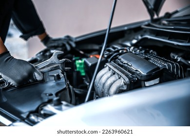 Car care maintenance and servicing, Close-up hand technician auto mechanic using the wrench to repairing change spare part car engine problem and car insurance service support. - Shutterstock ID 2263960621