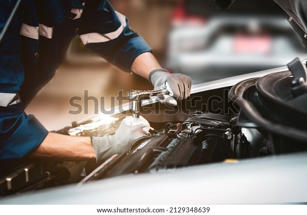 Car care
maintenance and servicing, Close-up hand technician auto mechanic
using the wrench to repairing change spare part car engine problem
and car insurance service
support.