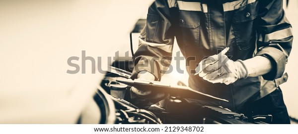 Car care\
maintenance and servicing, Close-up hand technician auto mechanic\
checking inspection list after repairing change spare part car\
engine problem and car insurance\
service.