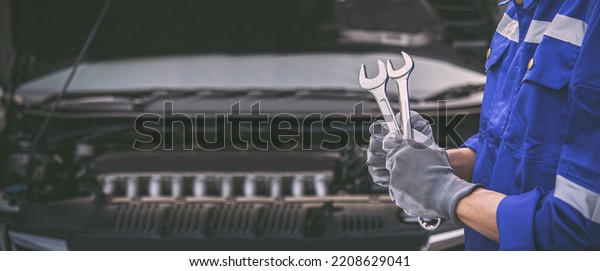 Car care maintenance and servicing, Close-up
hand technician auto mechanic holding the wrench to repairing
change spare part and fix car engine problem or car insurance
service support concepts.