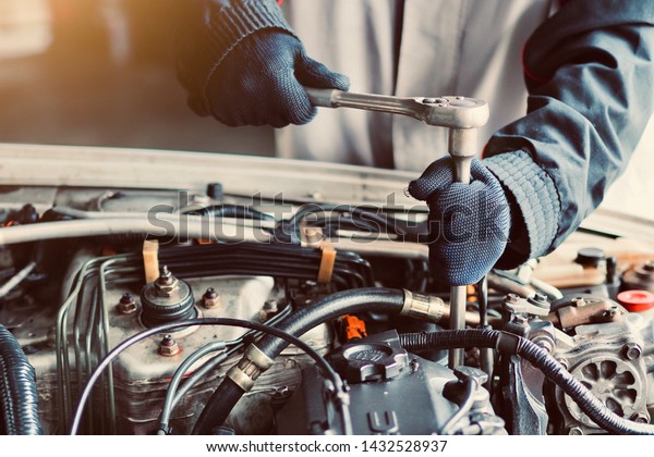 Car care, car mechanic are holding tools for\
repairing cars in their\
hands.
