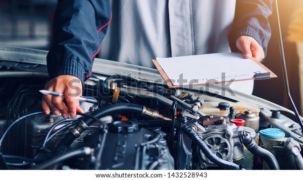 Car care, car mechanic
are waiting to check the engine and record the information on the
service list.