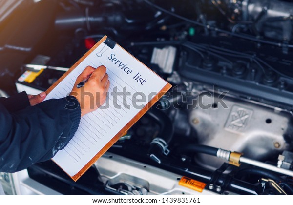 Car care, car mechanic\
are waiting to check the engine and record the information on the\
service list.