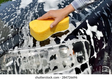 Car Care - Woman Washing A Car By Hand Using A Sponge