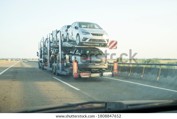 Car carrier trailer on divided highway road. View\
from the inside of the car