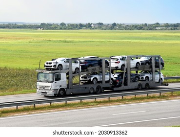 Car Carrier Trailer Transports BMW X1 Cars On Highway. Auto Transport And Car Shipping Services Concept. Truck With Semi-remorque. Cars Shipping And Transporter. Russia, Smolensk, August 25, 2021
