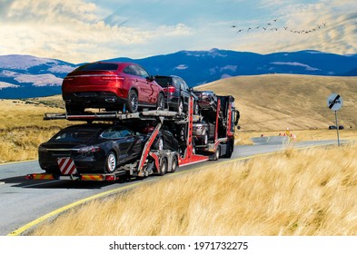 Car carrier. Car transporter truck. Mountains, blue skies and flying birds. No logo.