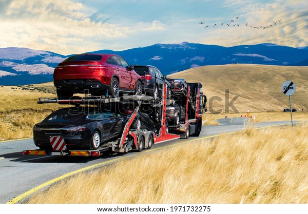 Car carrier. Car transporter truck.\
Mountains, blue skies and flying birds. No\
logo.