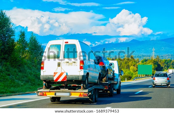 Car carrying trailer with mini vans on the
asphalt road in Slovenia.