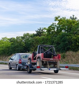 Car Carrying Trailer With An UTV Off-road Vehicle On Highway Road 