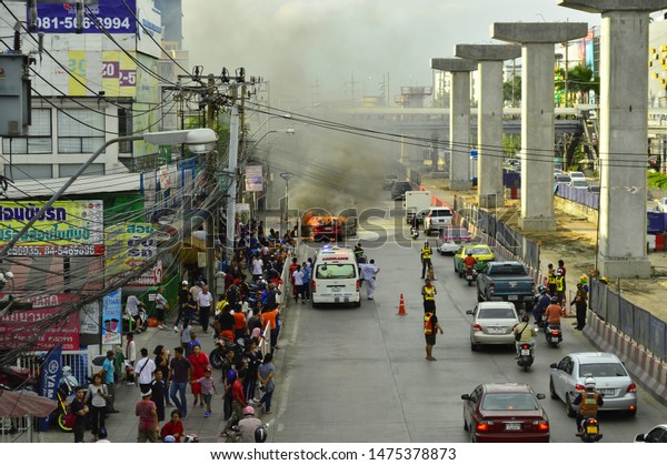 Car\
catches fire due to short circuit on the road. Stand by ambulance\
arrived at the scene of the incident with the staff. Srinakarin Rd,\
Bkk, Thailand on June 8,2019, Road accident\
concept