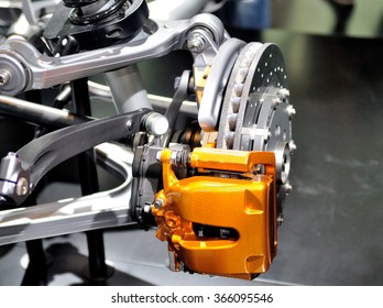 Car ceramic disc brake with yellow caliper, and  front suspension.