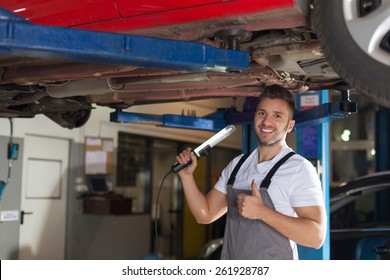 Car Chassis Corrosion Protection Approved. Smiling Man In Workwear Checking Car Chassis And Showing Thumb Up.