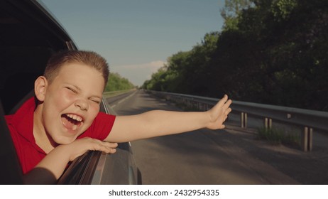 car, child, kid, boy, teenager, trip, road, travel, vacation, young boy leans out car window, resting his arms smiling coyly, enjoys warm day. road stretches into distance, flanked by greenery under - Powered by Shutterstock