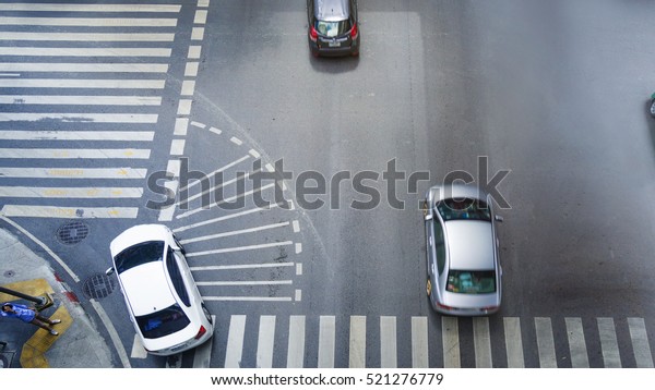 car city street on top view run on the pedestrian\
crosswalk sign on and turn left at intersection on ciity road\
(Aerial city road view)