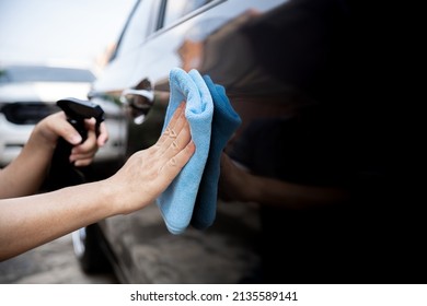 Car Clean Concept, Hand A Man Holding Microfiber Cloth And Clean Spray Wax To Take Care Of The Surface Of The Car From Washing 