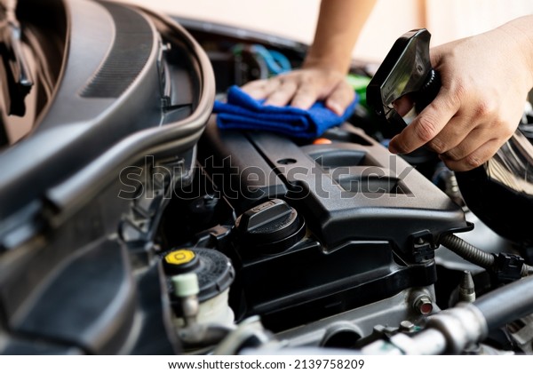 Car clean\
concept, Hand a man holding clean spray cleaner and microfiber\
cleaning engine room of car after car wash for the cleanliness and\
maintenance of the car 