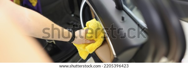 Car cleaner that cleans car\
door panel with microfiber cloth. Hand cleaning car interior\
concept