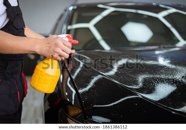 Car cleaning auto service : the man sprays water\
- car detailing concepts