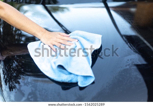 Car\
cleaning.\
The hand of a man using a car\
towel.