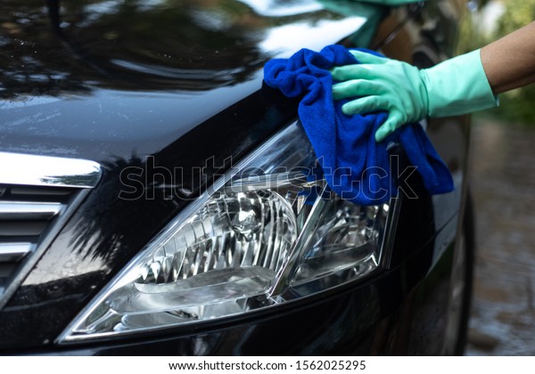 Car\
cleaning.\
The hand of a man using a car\
towel.