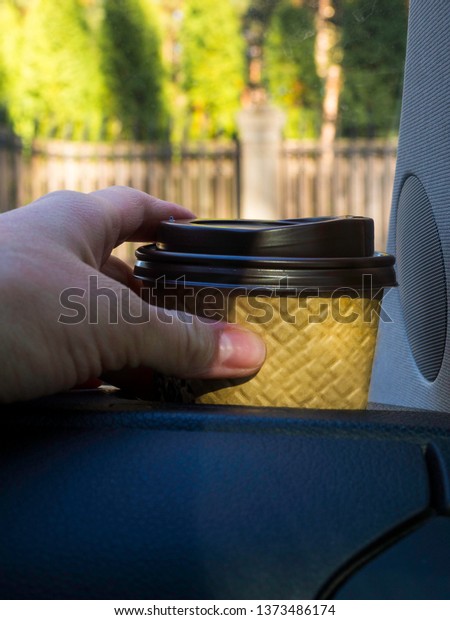 car coffee\
woman hand hold paper cup inside\
car