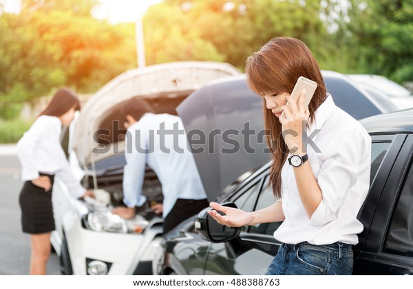 Car collision. driver man\
and woman examining damaged automobile cars after crash accident in\
city