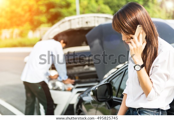Car collision. driver man\
and woman examining damaged automobile cars after crash accident in\
city