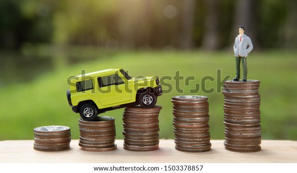 Car costs concept. Finance and car loan, saving money\
for a car. Miniature car model and financial statement with coins.\
