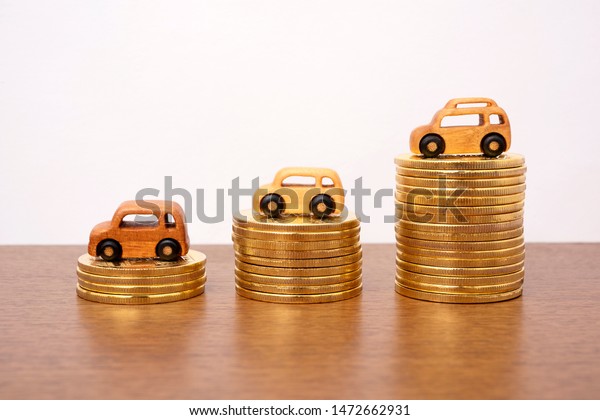Car costs concept.\
Wooden cars and coins. 