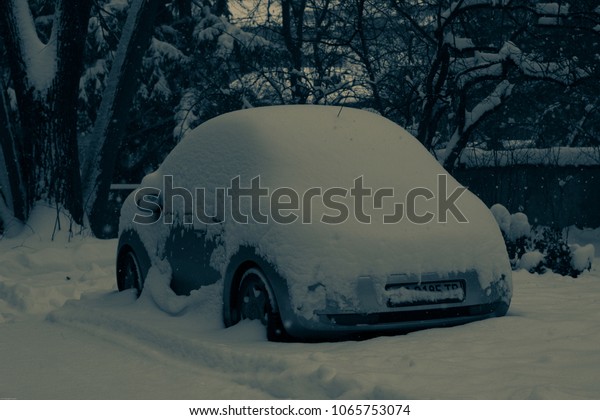 A car covered\
with 30-40 centimeters of spring snow in house yard, 03.2018,\
Sofia, Bulgaria, European\
Union
