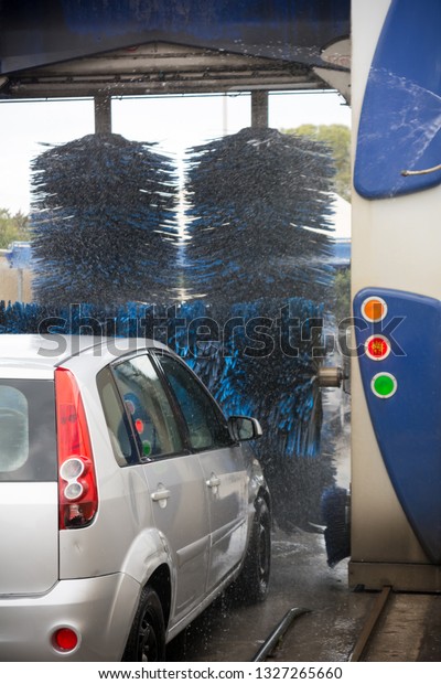 Car Covered by\
Active Foam During Car Washing entering the Brushes of a Washing\
Machine on Blur\
Background-8