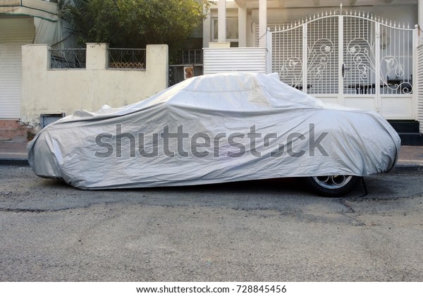 the car\
covered with a cover stands on the\
street