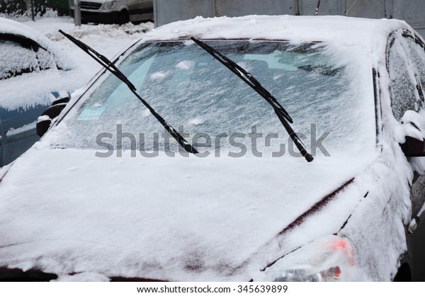 Car covered\
with fresh white snow in early\
winter