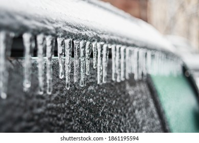Car covered with ice and icicles after freezing rain. Ice covered car window close up. Bad winter weather, ice storm in November Vladivostok. Winter frosty scenes.