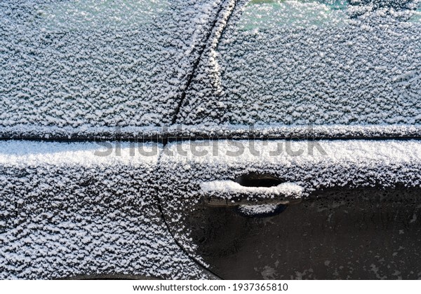 Car covered with ice and icicles after freezing\
rain. Ice covered car window close up. Bad winter weather, ice\
stormWinter frosty scenes.