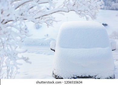 Car Covered With Snow After Winter Storm. Vehicle Parked Snowy Tree. Driveway With Family Car After Heavy Snow Blizzard.