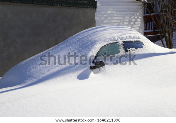 Car covered with\
snow in Montreal, canada.