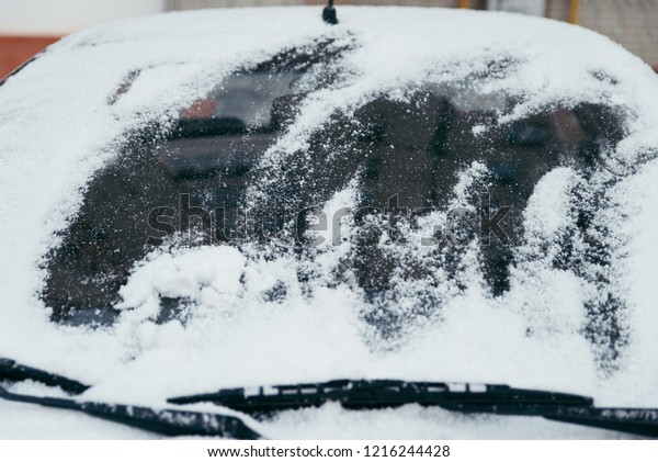 car covered with snow on outdoors parking in\
winter day. lifestyle