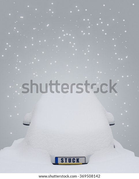 Car covered in snow with the word\
stuck written on the license plate and snow flakes\
falling