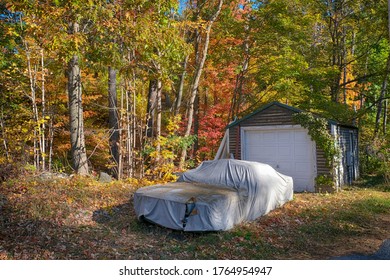 Car Covered With Tarp In Front Of Garage