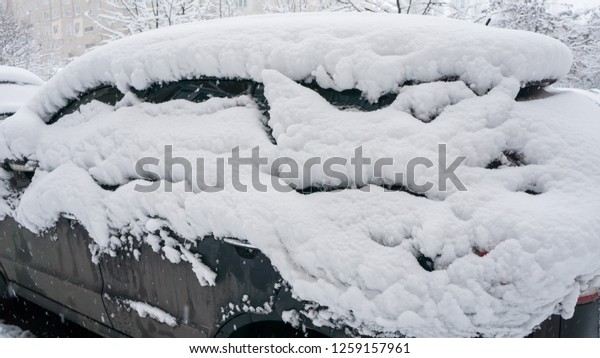 The car, covered with thick layer of snow. Negative\
consequence of heavy snowfalls. the left part of the car covered\
with snow