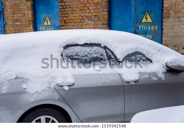 The car, covered with thick layer of snow.\
Negative consequence of heavy snowfalls. parked cars covered with\
snow during snowing in winter\
time\

