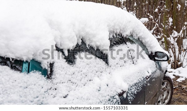 The car, covered\
with thick layer of snow. 