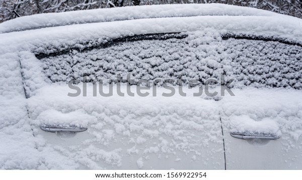 The car, covered with thick layer of snow.\
Negative consequence of heavy snowfalls. Side hundred cars with\
different patterns.