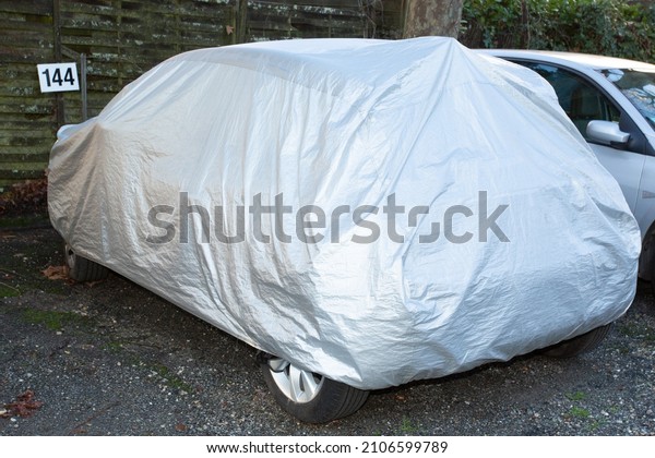 Car\
covered with waterproof cloth soft cover in\
street