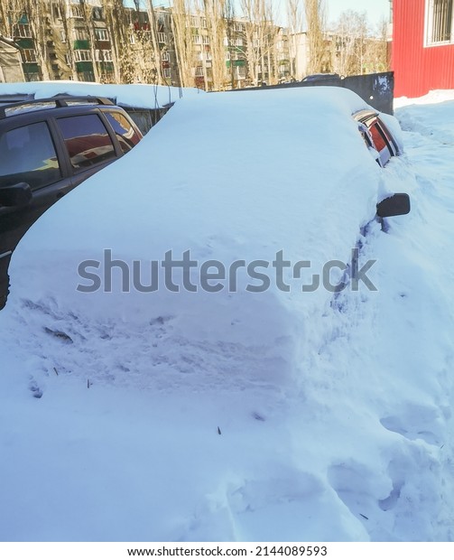 Car covered with white\
snow in winter.