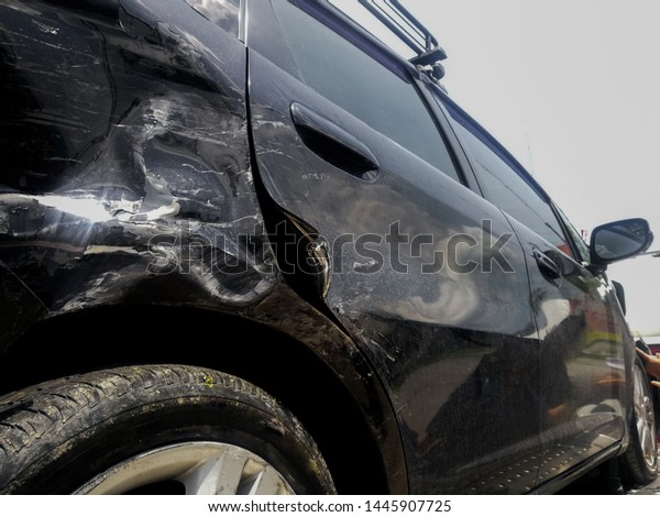 Car crash. Black car get damaged\
after the accident automobiles collision . Broken car on the side\
of the highway Waiting for rescue on the road\
.