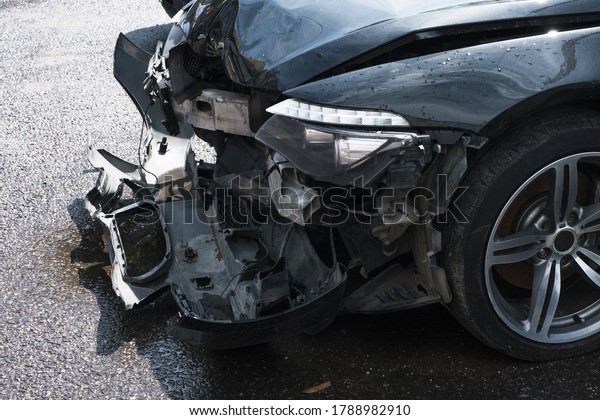 Car crash\
collision in urban street. Front of black color car big damaged and\
broken. Concept - End Of The Road.\
