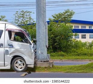 Car Crash. Front Of Van Crash With Electric Pole  Have Damaged And Broken By Accident On Traffic Road .